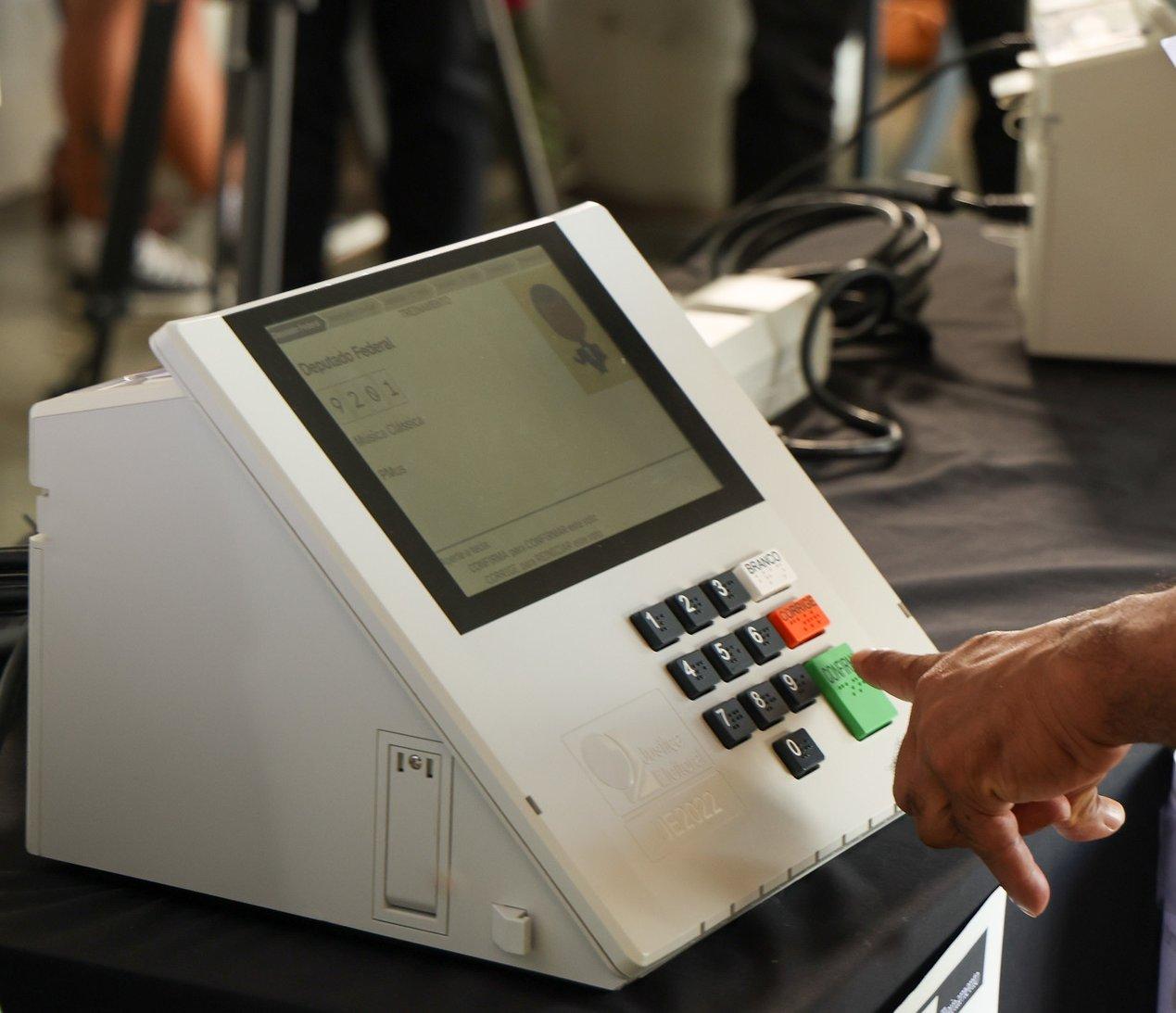 A voter practises on a machine with the 2026 interface, at a TSE event at the Brasília bus station in August. At the top of the screen is the bar with the voting steps